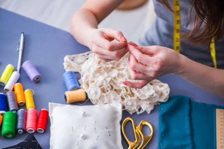 Woman tailor working on a clothing sewing stitching measuring faの写真素材