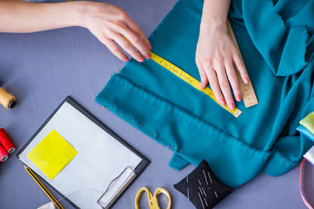 Woman tailor working on a clothing sewing stitching measuring faの写真素材