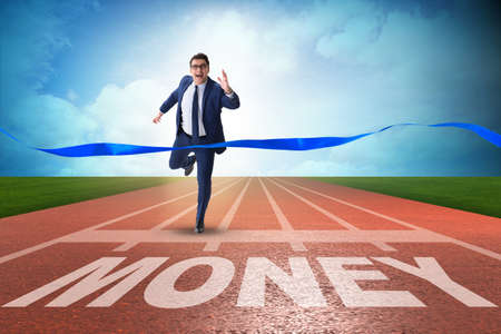 Businessman running towards money on trackの写真素材