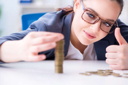 Businesswoman with coins in forex conceptの写真素材