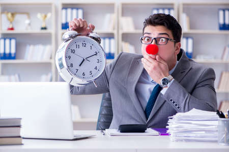 Clown businessman with alarm clock missing dieadlineの写真素材