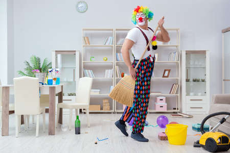 Funny clown doing cleaning at homeの写真素材