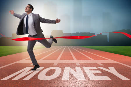 Businessman running towards money on trackの写真素材