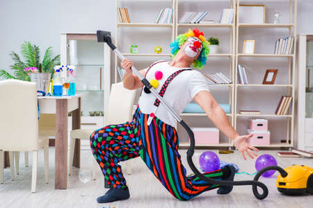 Funny clown doing cleaning at homeの写真素材