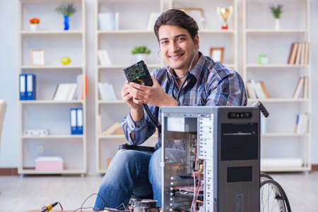 Computer repairman on wheelchair workingの写真素材
