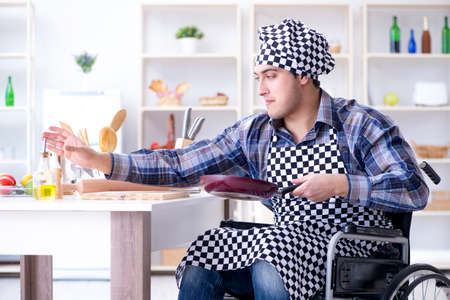 Disabled young husband frying at kitchenの写真素材