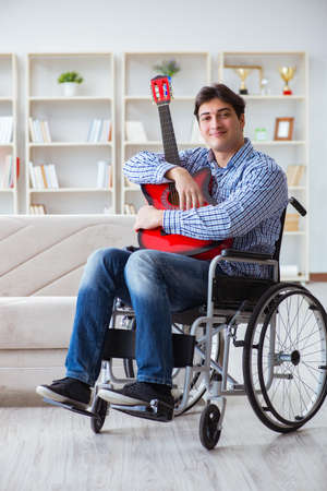 Disabled man playing guitar at homeの写真素材