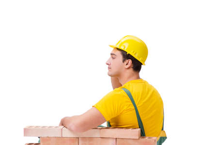 The handsome construction worker building brick wallの写真素材