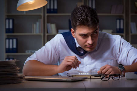 Businessman staying late in office for drugsの写真素材