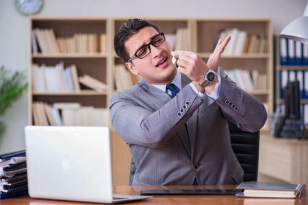 Drug addict businessman in the officeの写真素材