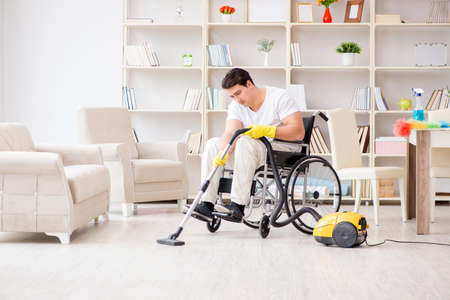 Disabled man with vacuum cleaner at homeの写真素材