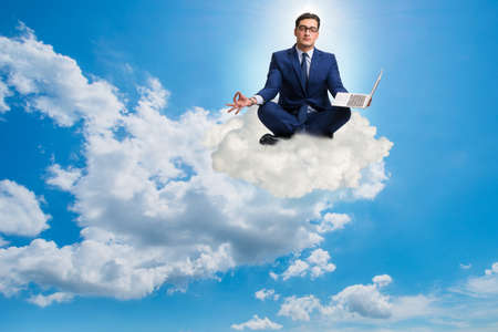 Businessman working on laptop in the skyの写真素材