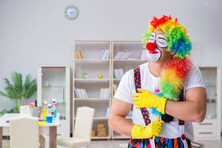 Funny clown doing cleaning at homeの写真素材