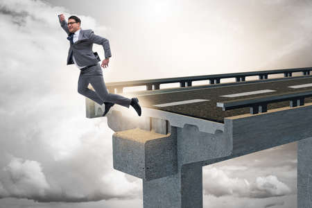 Businessman in uncertainty concept with broken bridgeの写真素材