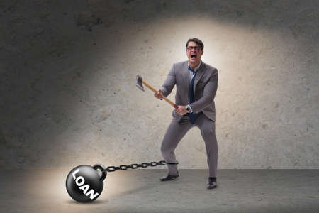 Debt concept with businessman escaping loan burden with axeの写真素材