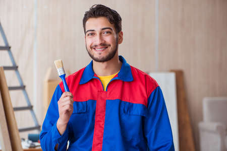 Yooung repairman carpenter working with paint paintingの写真素材
