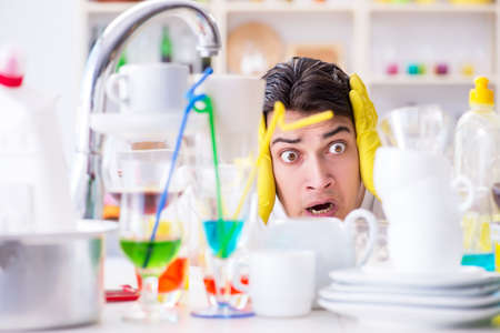 Man frustrated at having to wash dishesの写真素材