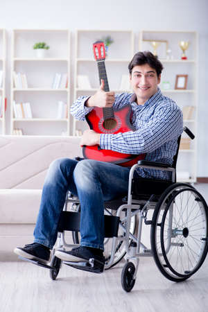 Disabled man playing guitar at homeの写真素材