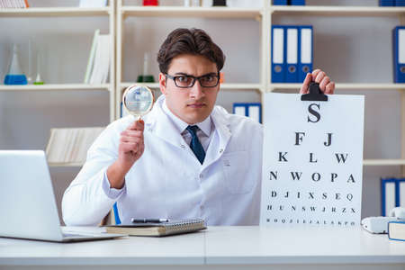 Doctor optician with letter chart conducting an eye test check