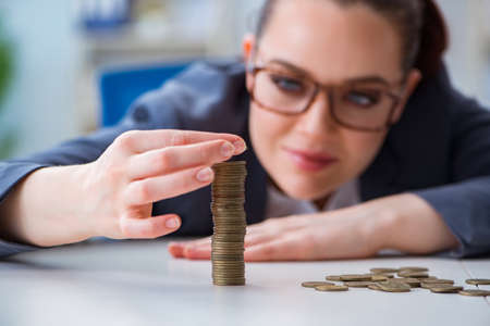 Businesswoman with coins in forex conceptの写真素材