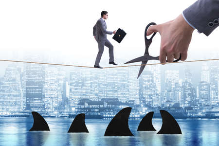 Hand cutting rope in business risk concept
