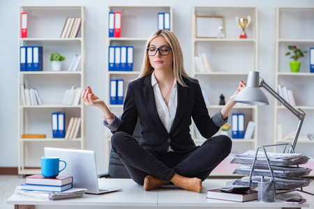 Businesswoman frustrated meditating in the officeの写真素材
