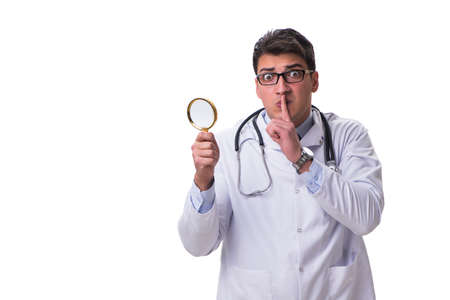 Young male doctor with a looking magnifying glass isolated on whの写真素材