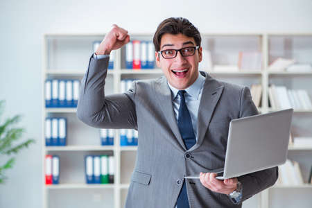 Businessman with laptop in the officeの写真素材