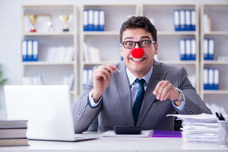 Clown businessman burning paper papers in the officeの写真素材