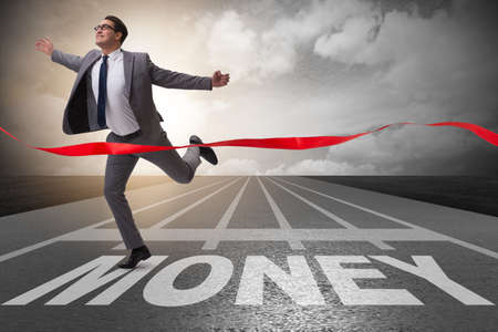 Businessman running towards money on trackの写真素材