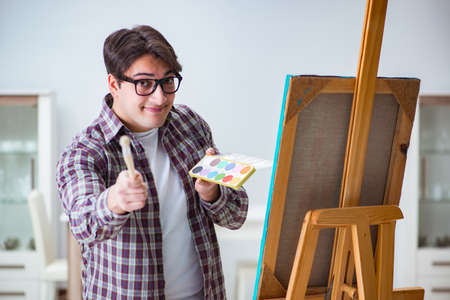 Young male artist drawing pictures in bright studioの写真素材
