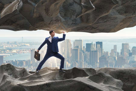 Businessman supporting stone under pressureの写真素材