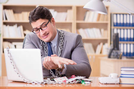 Young businessman addicted to online gambling cards playing in tの写真素材