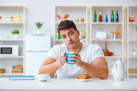 Man falling asleep during his breakfast after overtime workの写真素材