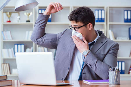 Businessman sweating excessively smelling bad in office at workpの写真素材