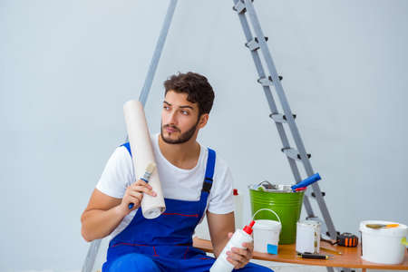 Repairman doing renovation repair in the house with paper wallpaの写真素材