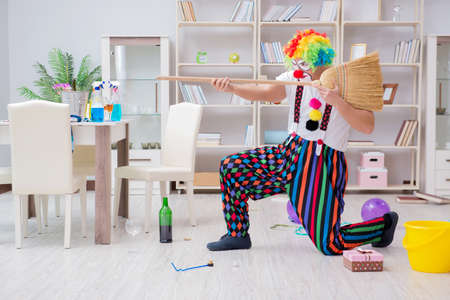 Funny clown doing cleaning at homeの写真素材