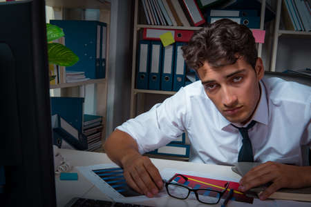 Man businessman working late hours in the officeの写真素材