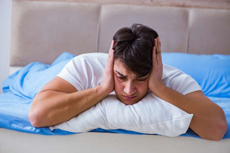 Man suffering from insomnia lying in bedの写真素材