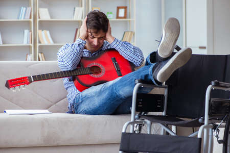 Disabled man playing guitar at homeの写真素材