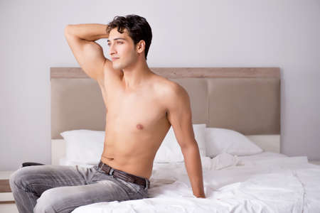 Young handsome shirtless guy showing nude torso sexy on bed at hの写真素材