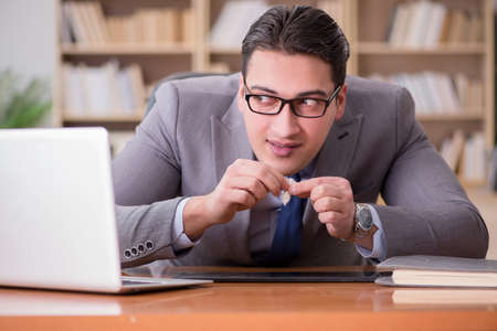 Drug addict businessman in the officeの写真素材