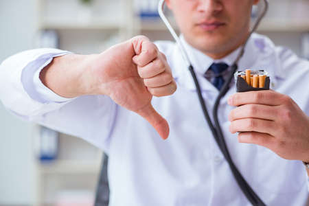 Male doctor in anti-smoking conceptwithcigarette packの写真素材