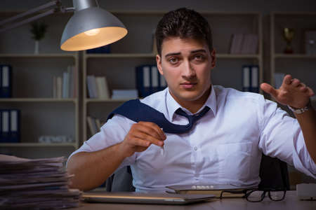 Businessman staying late in office for drugsの写真素材