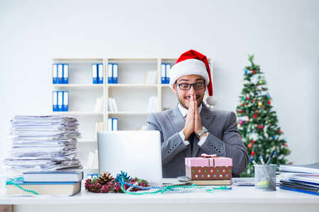 Young businessman celebrating christmas in the officeの写真素材