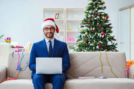 Businessman working at home during christmasの写真素材