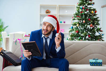 Businessman working at home during christmasの写真素材