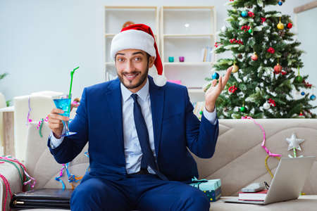 Businessman working at home during christmasの写真素材
