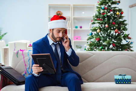 Businessman working at home during christmasの写真素材