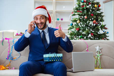 Businessman working at home during christmasの写真素材